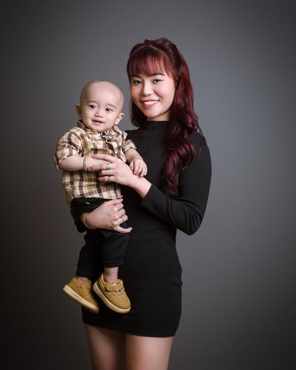 Maman souriante avec son bébé dans les bras
